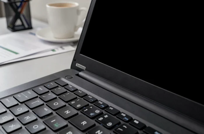 Gros plan sur le bouton power clignotant d'un ordinateur portable Lenovo avec écran noir